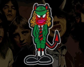 Op de afbeelding: Een geborduurde patch met een stripfiguur met een rode huid, geel haar en kleine hoorntjes. Het figuur draagt een groen pak, een groene pet met de letter A, een rood-zwart gestreepte das, witte sokken en grote zwarte schoenen met een rode staart.