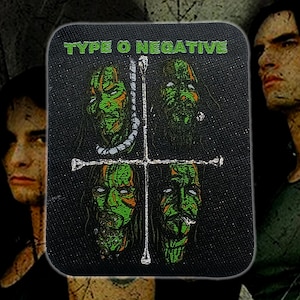 Puede incluir: Parche cuadrado negro con el nombre de la banda "TYPE O NEGATIVE" en letras verdes. El parche presenta cuatro caras de zombis verdes y naranjas dispuestas alrededor de una cruz blanca. El fondo tiene un diseño oscuro y texturizado.