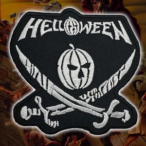 May include: Black patch with white embroidered design. The patch features the word "HELLOWEEN" above a pumpkin with a skull face, and crossed swords. The patch is a unique accessory.
