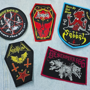 May include: Five embroidered fabric patches featuring heavy metal band logos and dark imagery. The collection includes circular, coffin-shaped, and shield-shaped designs in black, red, yellow, and blue, displaying text like Bathory, Venom, Sabbat, Nifelheim, and Destroyer 666.