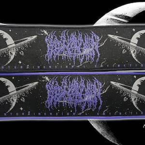 May include: Two black rectangular patches with a space theme. Each patch features a planet with rings and the text "INTERDIMENSIONAL EXTINCTION". The text "ABANDONED MORTALITY" is in a purple, stylized font. One patch has a black border, the other a purple border.