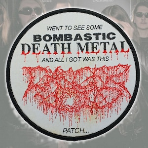 Puede incluir: Un parche redondo blanco con borde negro. Presenta el texto "WENT TO SEE SOME BOMBASTIC DEATH METAL AND ALL I GOT WAS THIS PATCH..." en negro y rojo, y un diseño abstracto rojo.