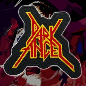 Op de afbeelding: Zwart geborduurde patch met de tekst "DARK ANGEL" in geel en rood. De patch heeft een unieke vorm met een zwarte rand, geschikt voor kleding of accessoires.