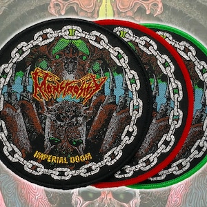 Pode incluir: Três patches redondos pretos com borda de corrente e um gráfico central. Os patches têm bordas vermelhas e verdes. O gráfico apresenta um monstro, o texto "MONSTROSITY" e "IMPERIAL DOOM".