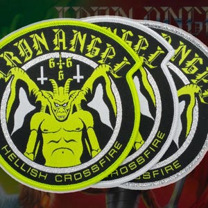 Op de afbeelding: Drie cirkelvormige geborduurde patches met een neongele gehoornde figuur op een zwarte achtergrond. De tekst IRON ANGEL staat in een boog bovenaan, met HELLISH CROSSFIRE onderaan. Het getal 666 en twee omgekeerde kruisen staan boven de figuur.
