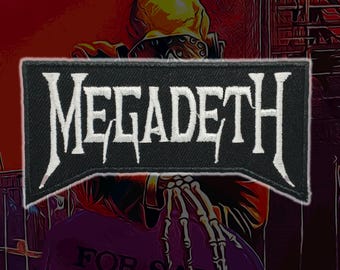 May include: A rectangular embroidered patch featuring the word MEGADETH in white, stylized, sharp-edged lettering against a solid black background. The patch has a distinct, jagged bottom edge and a thick, black stitched border surrounding the text.