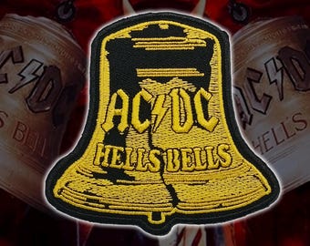 Op de afbeelding: Een klokvormige geborduurde patch met een zwarte achtergrond en gele stiksels. Het ontwerp toont de tekst AC/DC met een bliksemschicht in het midden en de woorden HELLS BELLS eronder, alles uitgevoerd in een vetgedrukt geel lettertype.