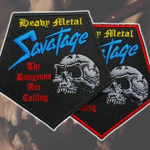 Peut inclure: Écussons brodés avec le texte "Heavy Metal Savatage" et un motif de crâne. L'un des écussons a une bordure noire, l'autre une bordure rouge. Le texte "The Dungeons Are Calling" est également inclus.