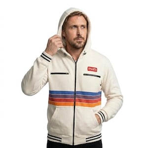 May include: An off-white zip-up hoodie featuring a horizontal multi-colored stripe pattern in blue, purple, red, and orange across the chest. The garment includes a black front zipper, two chest pockets with black zippers, and black striped cuffs.