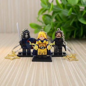 May include: A white ceramic mug with a black handle and the text "But First, Coffee" in a black, handwritten-style font. The mug is on a white surface.