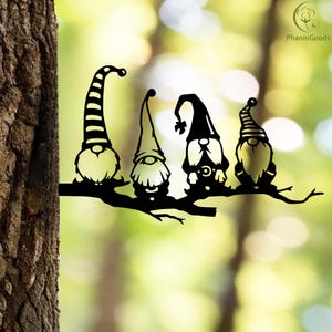 May include: Black metal garden art featuring four whimsical gnomes perched on a branch. Each gnome has a unique hat design, including stripes and pointed shapes. The art is designed to be mounted on a tree or fence, adding a touch of fantasy to outdoor spaces.