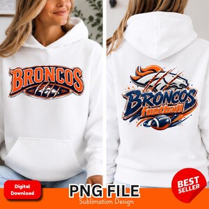 Puede incluir: Una sudadera con capucha blanca que presenta un diseño gráfico de la palabra BRONCOS en naranja y azul marino con marcas de garras. La parte posterior de la sudadera muestra una versión más grande del logo con el texto BRONCOS football.