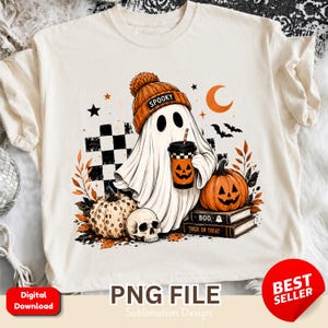 Peut inclure: Un t-shirt crème avec un motif représentant un fantôme portant un bonnet orange avec le mot SPOOKY, tenant une tasse de café, entouré d'une citrouille, d'un crâne, d'une citrouille d'Halloween et de livres étiquetés BOO et TRICK OR TREAT.