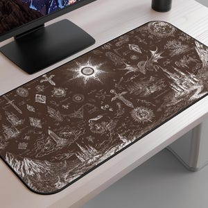 May include: A rectangular brown mouse mat with a black border. The mat features a detailed white illustration of fantasy elements, including a castle, dragon, swords, and celestial bodies. The design is reminiscent of a map or a mystical scroll.