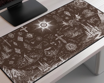 Puede incluir: Una alfombrilla de ratón rectangular marrón con borde negro. La alfombrilla presenta una detallada ilustración blanca de elementos de fantasía, incluyendo un castillo, un dragón, espadas y cuerpos celestes. El diseño recuerda a un mapa o pergamino místico.