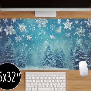 Könnte beinhalten: Winter-Schreibtischunterlage mit einer verschneiten Waldszene mit fallenden Schneeflocken. Die Matte ist 40,6 x 81,3 cm groß und hat ein blau-weißes Farbschema. Das Design umfasst detaillierte Illustrationen von Kiefern und Schneeflocken.