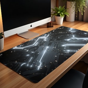 May include: A black and gray computer mouse pad with a circuit board design. The pad features glowing white lines and dots, creating a futuristic aesthetic. The pad is rectangular and sits on a wooden desk, with a computer monitor in the background.
