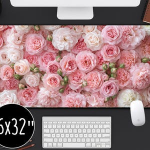 May include: A floral mouse pad featuring a dense arrangement of pink and white roses. The pad measures 16 x 32 inches and is designed for use with a computer mouse and keyboard. The design includes a variety of rose types and shades.