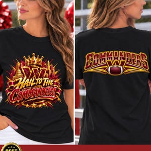 May include: A black t-shirt featuring a graphic design with a gold crown, the text "HAIL TO THE COMMANDERS!" and a city skyline on the front, and the text "COMMANDERS" with a football graphic on the back in burgundy, gold, and white colors.