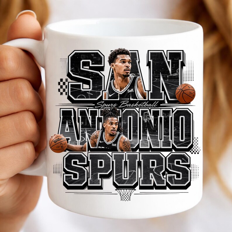 May include: White ceramic mug featuring the words "SAN ANTONIO SPURS" in a black and white design. The mug includes images of two basketball players and basketballs. The words "Spurs Basketball" are also printed on the mug.