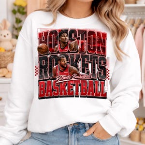 May include: White sweatshirt featuring the text "HOUSTON ROCKETS BASKETBALL" in red and black, with images of two basketball players. A basketball is also visible. The sweatshirt is a fan item.