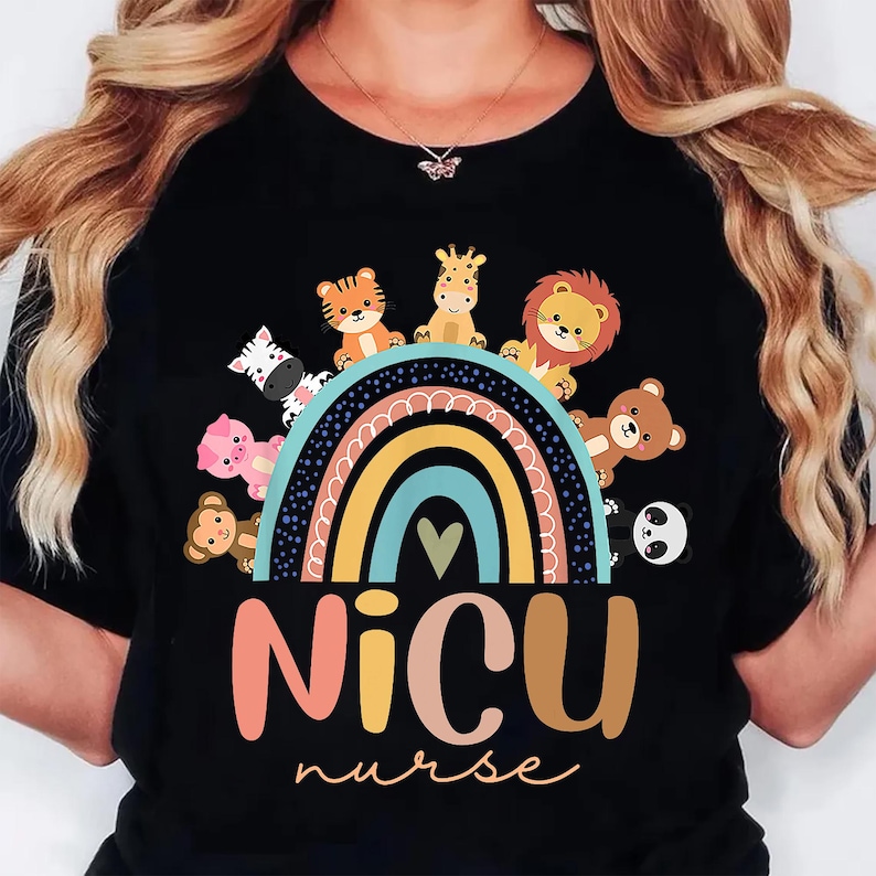 May include: Black t-shirt featuring a colorful rainbow design with cartoon animals, including a zebra, tiger, giraffe, lion, bear, panda, and monkey. The text "NICU nurse" is displayed below the rainbow in a playful font.