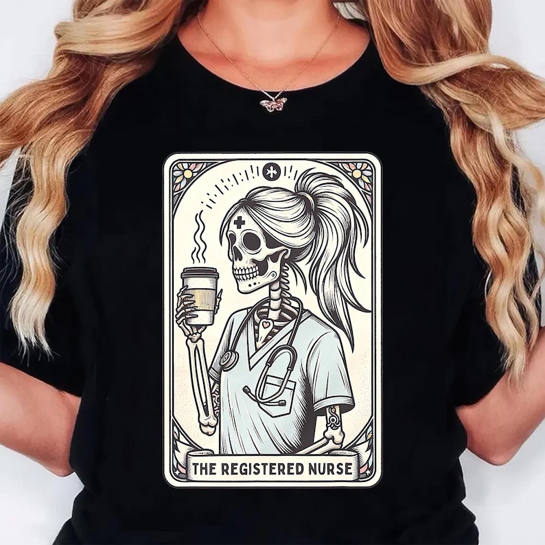 Pu&ograve; includere: T-shirt nero con grafica di un'infermiera scheletro che tiene una tazza di caff&egrave;, con uno stetoscopio e la scritta "THE REGISTERED NURSE". Il disegno &egrave; incorniciato in un bordo decorativo.