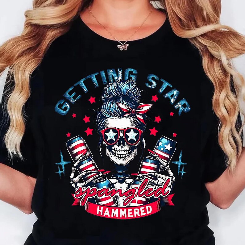 May include: Black t-shirt with a skull graphic wearing star-shaped sunglasses and a red, white, and blue bandana. The shirt features the text "GETTING STAR SPANGLED HAMMERED" with images of beer cans.