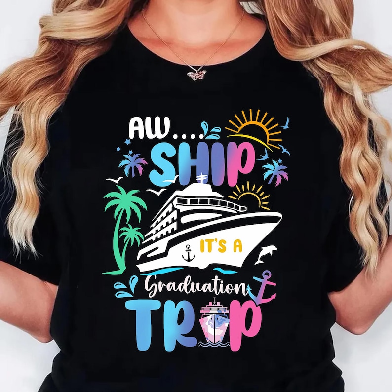 May include: Black t-shirt with a colorful graphic design. The design features a cruise ship, palm trees, a sun, and the words "AW...SHIP IT'S A Graduation TRIP" in various colors. Includes an anchor and a dolphin.