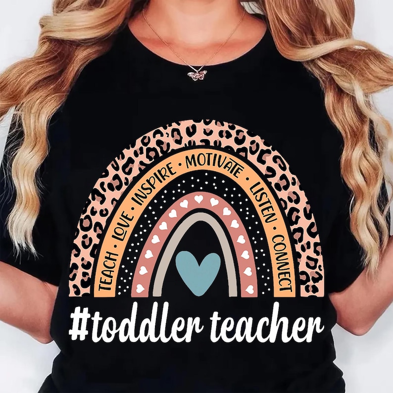 May include: Black t-shirt with a rainbow design. The rainbow features leopard print, hearts, and the words "Teach, Love, Inspire, Motivate, Listen, Connect." Below the rainbow is the text "#toddler teacher."