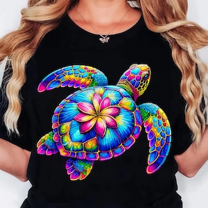May include: Black t-shirt featuring a vibrant, colorful sea turtle design. The turtle's shell is a mosaic of blues, greens, yellows, and pinks, with a central flower motif. The design is detailed and eye-catching, perfect for a casual look.