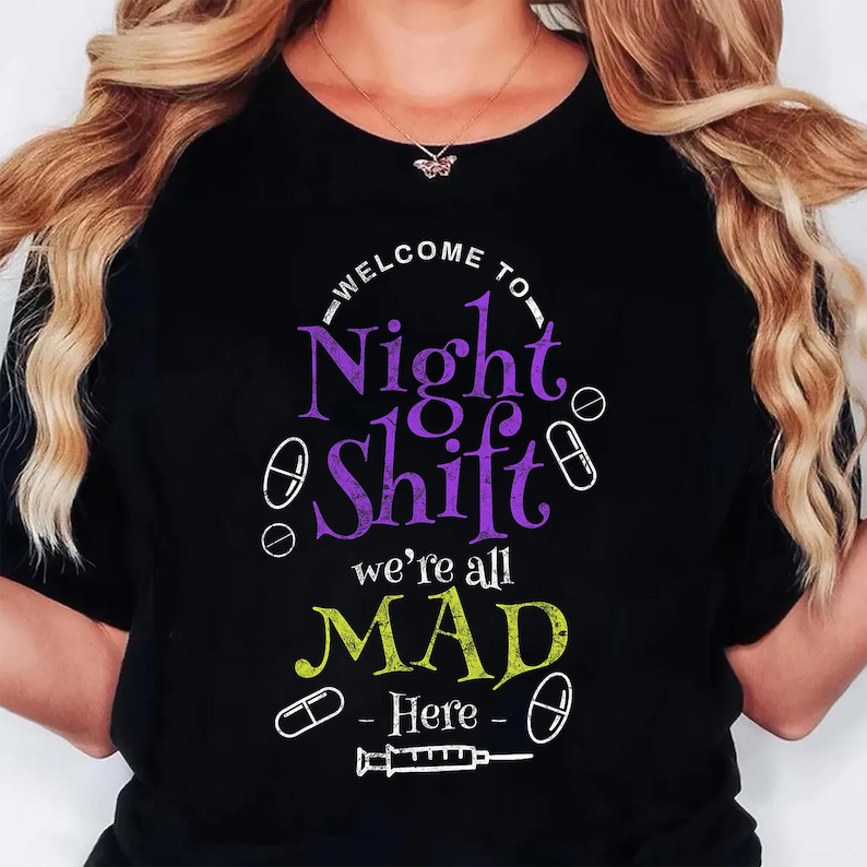 Pu&ograve; includere: T-shirt nera con le scritte "WELCOME TO Night Shift" in bianco e viola, e "we're all MAD Here" in giallo e verde. Il design include pillole e una siringa.