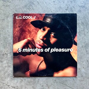 May include: A black and white album cover featuring a man wearing a black hat and a gold chain. The album title is "6 minutes of pleasure" and the artist is "LL Cool J".