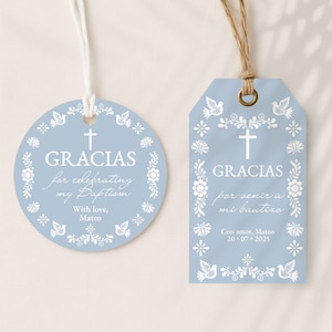 Pode incluir: Duas etiquetas de lembrancinhas de batismo azul claro com desenhos florais e pombas brancas. Uma etiqueta é redonda, a outra é retangular. Ambas as etiquetas têm a palavra "GRACIAS" e outro texto em espanhol.