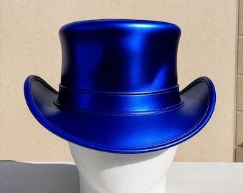 May include: A shiny, cobalt blue top hat with a wide brim and a band around the crown. The hat is displayed on a white mannequin head. The hat has a glossy finish and a classic, formal design.