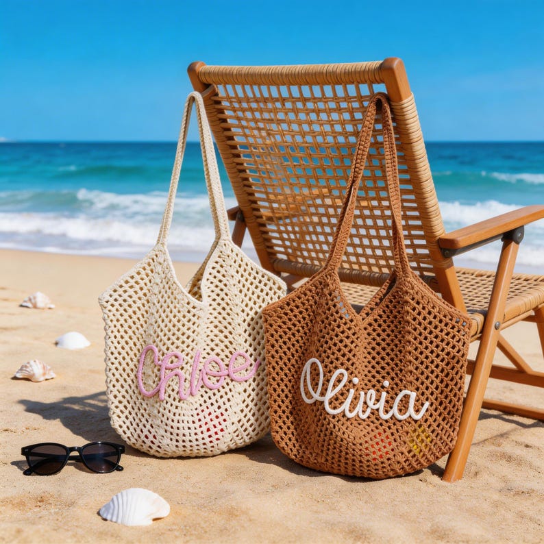 Op de afbeelding: Twee gehaakte tote bags met een open breipatroon. De cr&egrave;mekleurige tas is voorzien van de naam Chloe in roze schrijfletters, terwijl de bruine tas de naam Olivia in witte schrijfletters toont. Beide tassen hebben lange schouderbanden en een open ontwerp.