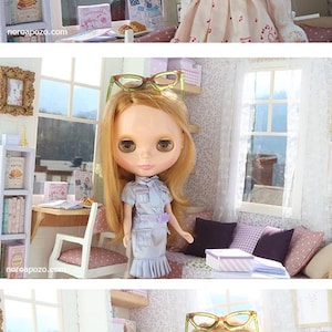 Pode incluir: Cena de casa de bonecas com duas bonecas loiras. Uma boneca usa um vestido rosa com notas musicais, a outra um traje cinza. A cena inclui m&oacute;veis em miniatura, livros e objetos decorativos.