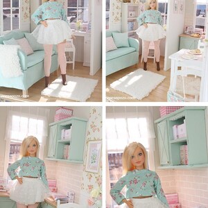 May include: A trio of cream-glazed ceramic mugs with a speckled finish. Each mug is adorned with a hand-painted design: a blue and green leaf, a yellow flower, and a red berry. The mugs have a simple, rounded form.