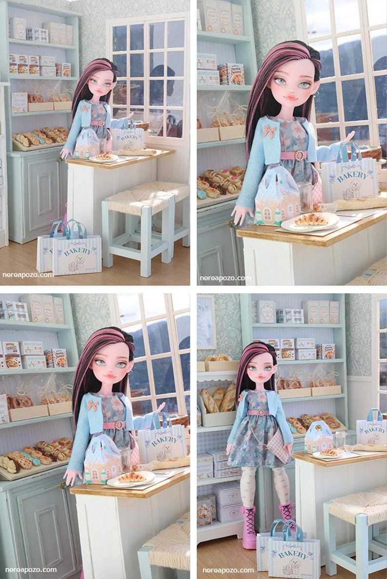 May include: A doll with long dark hair featuring pink highlights, wearing a light blue cardigan over a floral dress, white patterned tights, and pink boots. The doll stands in a miniature bakery setting with shelves of bread and a small table.