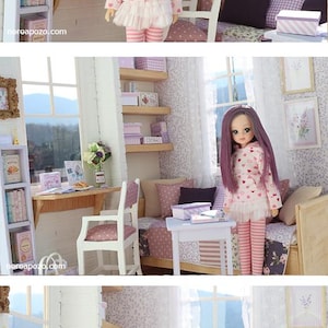 Pode incluir: Uma boneca com longos cabelos roxos e uma roupa rosa com padr&otilde;es de cora&ccedil;&atilde;o est&aacute; em um quarto em miniatura. O quarto apresenta uma mesa, prateleiras e uma cama, todos decorados em tons de rosa e branco. A boneca est&aacute; vestindo um top rosa com cora&ccedil;&otilde;es vermelhos, uma saia branca e leggings listradas rosa.