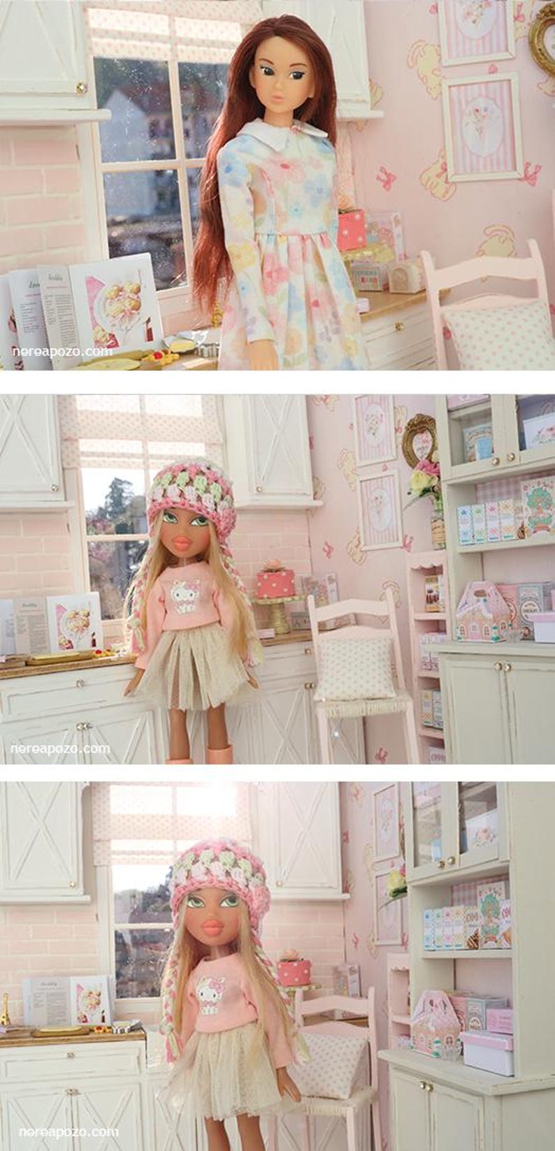 May include: A doll in a floral dress stands in a miniature kitchen scene. The doll has long brown hair and is surrounded by miniature furniture, including a cabinet, chair, and table. The scene is decorated in soft pink tones.