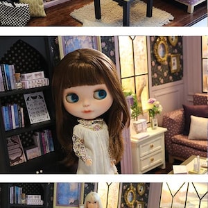 May include: A miniature dollhouse living room scene featuring a doll with long brown hair, a cream-colored dress, and blue eyes. The room includes a purple fireplace, a purple polka-dot sofa, a black coffee table, and a black bookshelf filled with books.
