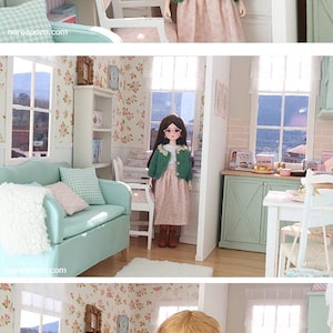 May include: A dollhouse interior scene with a doll in a green jacket and pink dress. The room has floral wallpaper, a sofa, and a desk. The scene is well-lit, with a window in the background, creating a charming, miniature setting.