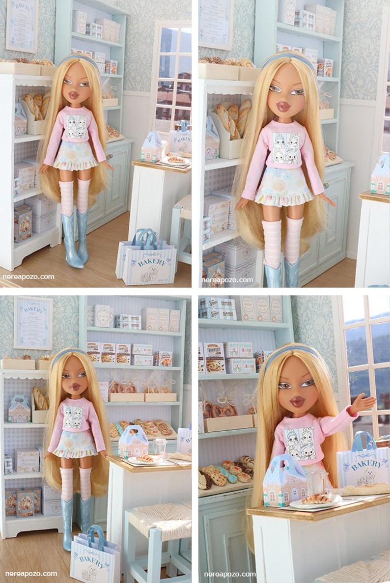 May include: A blonde doll with long hair wearing a light pink long-sleeve shirt with a graphic print, a ruffled skirt, striped leg warmers, and light blue boots. The doll is positioned in a miniature bakery setting with shelves of baked goods.