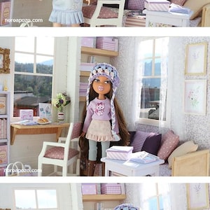 Pode incluir: Uma cena de casa de bonecas com uma boneca vestida com uma roupa azul clara, perto de uma secret&aacute;ria e uma cadeira. O quarto &eacute; decorado em cores pastel com uma janela com vista para uma vista panor&acirc;mica. A cena inclui m&oacute;veis em miniatura e objetos decorativos.