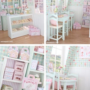 K&ouml;nnte beinhalten: Eine Miniatur-B&auml;ckerei-Szene in Pastellgr&uuml;n und Rosa. Vitrinen halten Geb&auml;ck, Regale sind mit Schachteln best&uuml;ckt und kleine Tische und St&uuml;hle sind aufgestellt. Die Szene enth&auml;lt den Text "Bakery" auf Taschen und Schachteln.