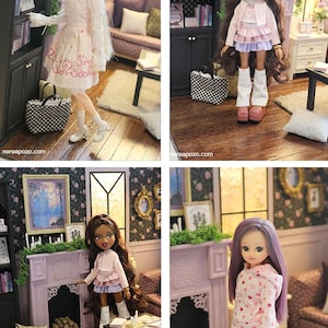 May include: A collection of four dolls in a miniature living room setting. The dolls feature varied hair colors and outfits, including dresses, skirts, and hoodies. They are positioned near a fireplace, a bookshelf, and a small table.