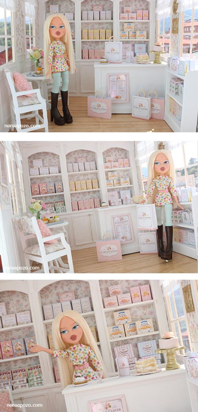 K&ouml;nnte beinhalten: Eine Miniatur-Puppenhaus-B&auml;ckerei mit einer blonden Puppe mit langem Haar, die ein gebl&uuml;mtes Oberteil, eine hellblaue Leggings und dunkelbraune Stiefel tr&auml;gt. Der Laden enth&auml;lt wei&szlig;e Regale mit kleinen Schachteln, eine Theke und Einkaufst&uuml;ten mit der Aufschrift Cake & Clover.