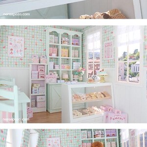 K&ouml;nnte beinhalten: Ein Miniatur-B&auml;ckerladen mit Regalen, Vitrinen und Tischen. Die Regale sind mit Schachteln und Geb&auml;ck gef&uuml;llt. Ein Kuchen mit einem Teddyb&auml;renaufsatz steht auf einem goldenen St&auml;nder. Die W&auml;nde sind mit einem hellgr&uuml;nen und wei&szlig;en Karomuster verziert.