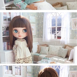 Może przedstawiać: Trzy lalki w miniaturowym pokoju. Lalki mają duże oczy i noszą sukienki i bluzki. Pok&oacute;j posiada regał, okno i kwiatową tapetę. Lalki są blond i brunetkami.